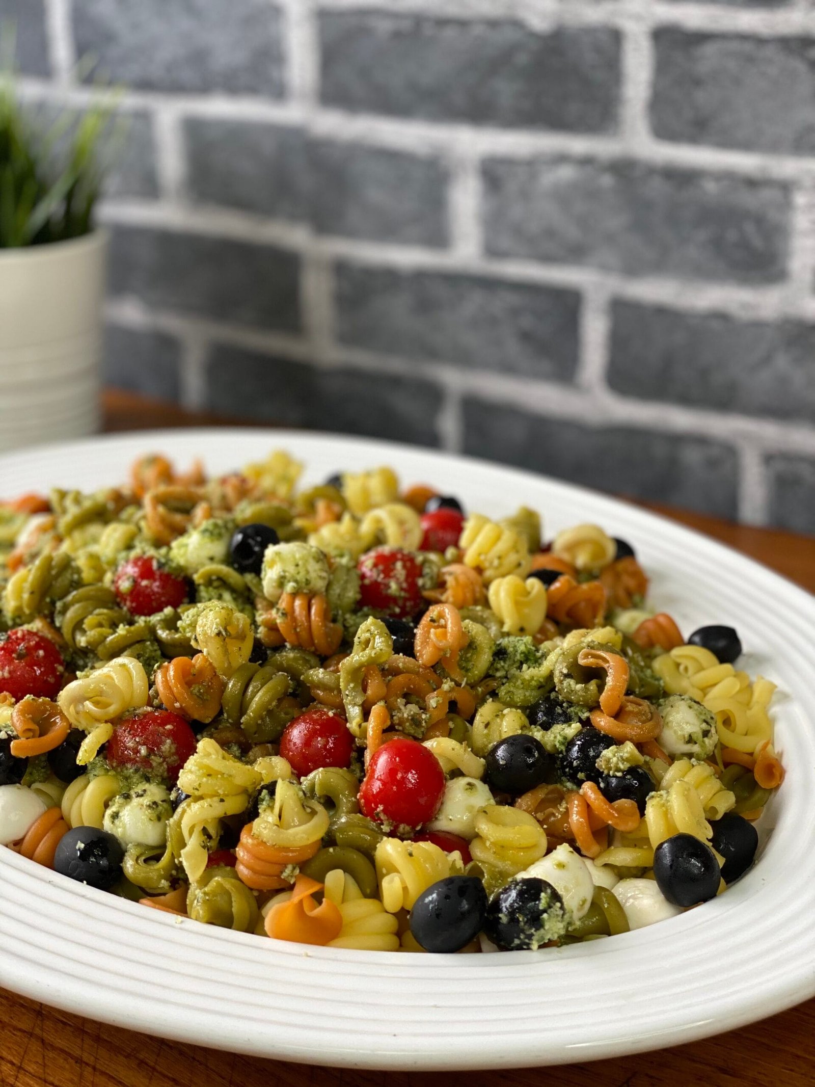 Ensalada italiana con pasta corta, aceitunas negras, tomates cherry y aderezo de limón. Plato fresco, lleno de nutrientes esenciales y antioxidantes, ideal para una comida ligera y deliciosa.
