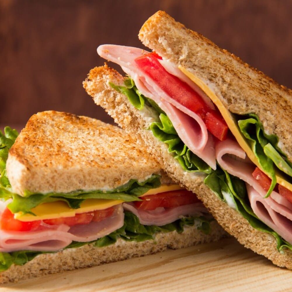 Club Sándwich saludable con pan crujiente, Jamón, jitomate, lechuga y queso, desayuno saludable con proteínas y cocina casera. Un desayuno nutritivo y lleno de sabor