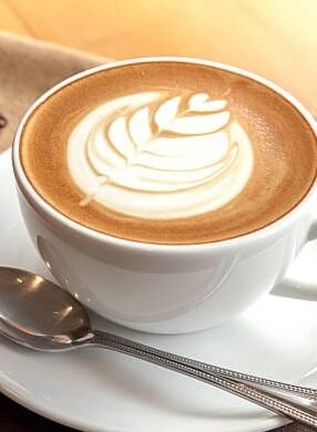 Café con leche caliente, suave y cremoso, ideal para acompañar con panque de nata o bísquet esponjoso. Bebida reconfortante y deliciosa, perfecta para un desayuno lleno de energía y sabor.