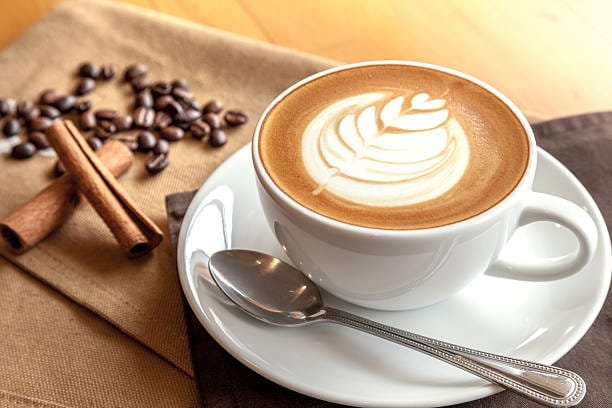Café con leche caliente, suave y cremoso, ideal para acompañar con panque de nata o bísquet esponjoso. Bebida reconfortante y deliciosa, perfecta para un desayuno lleno de energía y sabor.