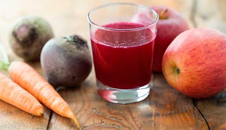 Jugo fresco de manzana, zanahoria y betabel, rico en antioxidantes, vitamina A y C, ideal para mejorar la circulación y detoxificar el cuerpo. Bebida natural llena de nutrientes esenciales para empezar el día con energía.