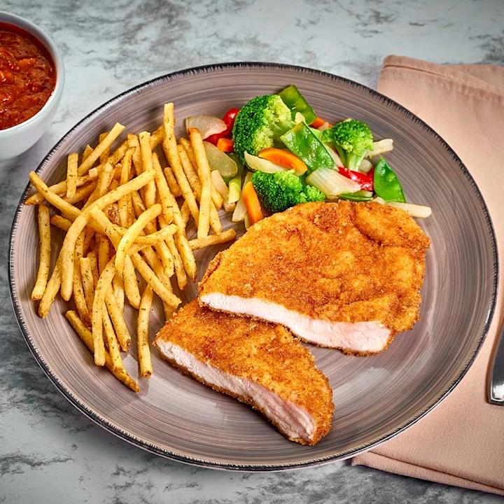 Milanesa de pollo empanizada con papas fritas y verduras al vapor. Platillo completo con proteína magra, vegetales frescos y sabor casero de calidad.