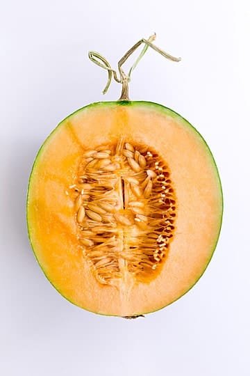 Melón fresco, partido a la mitad con semillas naturales, saludable, fresco, rico, fresco y natural, ligero para un desayuno por la mañana.